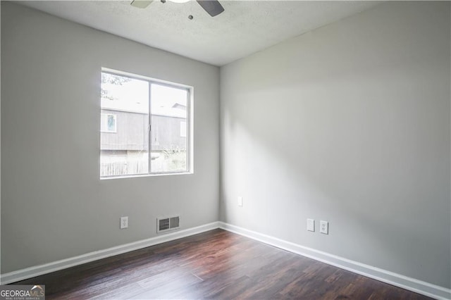 unfurnished room featuring a textured ceiling, dark wood-type flooring, and ceiling fan