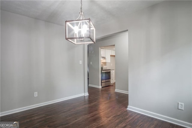 unfurnished dining area with a chandelier, a textured ceiling, and dark hardwood / wood-style flooring