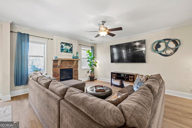 living room featuring ceiling fan, a fireplace, wood-type flooring, and plenty of natural light