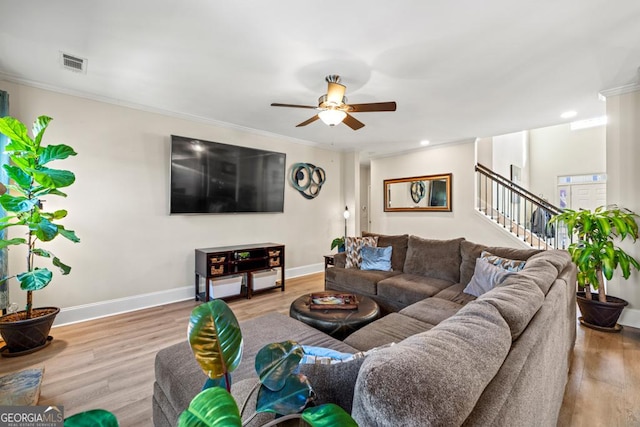 living room with ceiling fan, light wood-type flooring, and crown molding