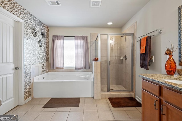 bathroom featuring vanity, tile patterned flooring, and plus walk in shower