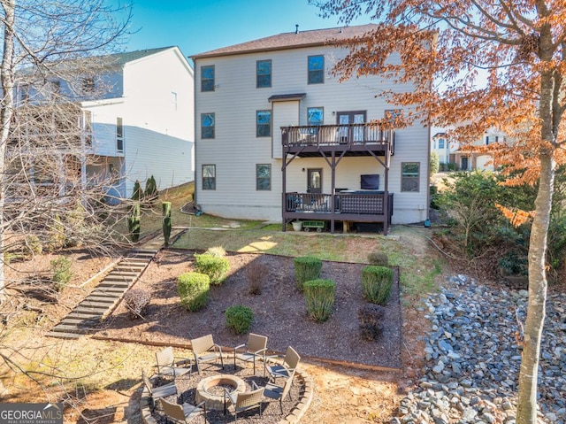 back of property with a wooden deck and a fire pit