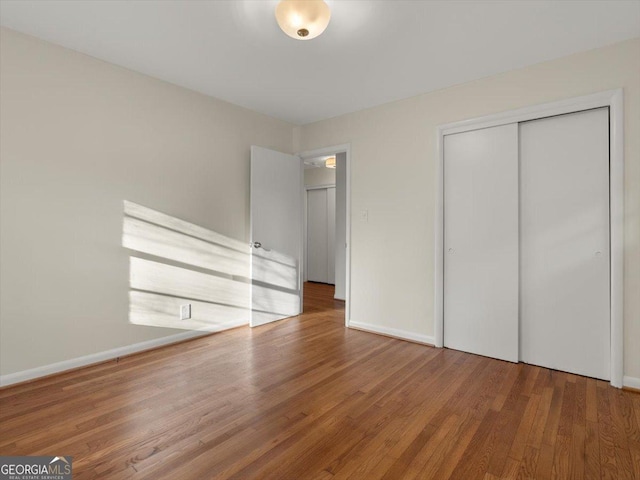 unfurnished bedroom featuring a closet and wood-type flooring