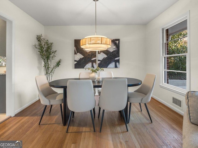 dining space with hardwood / wood-style flooring