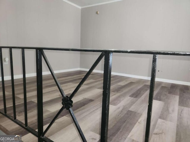 stairs featuring wood-type flooring and ornamental molding