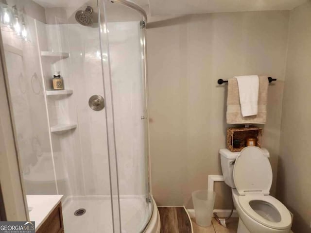 bathroom with vanity, toilet, and a shower with shower door