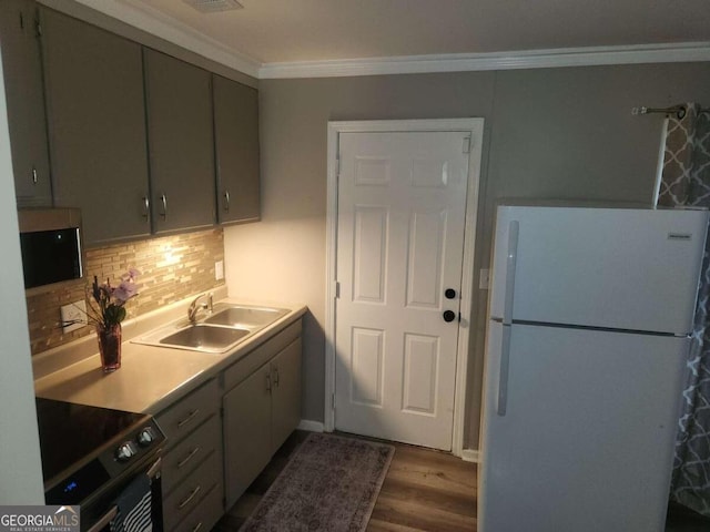 kitchen with backsplash, crown molding, sink, black range with electric cooktop, and white fridge