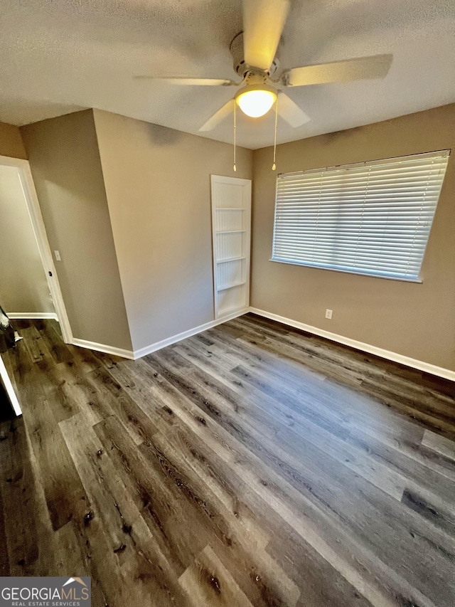 unfurnished bedroom with a textured ceiling, ceiling fan, and dark wood-type flooring