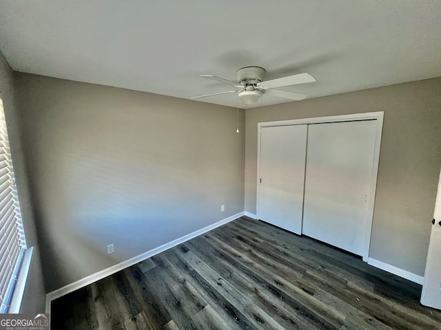 unfurnished bedroom with ceiling fan, dark hardwood / wood-style floors, and a closet