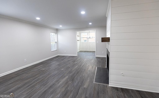 unfurnished living room featuring dark wood-type flooring and ornamental molding