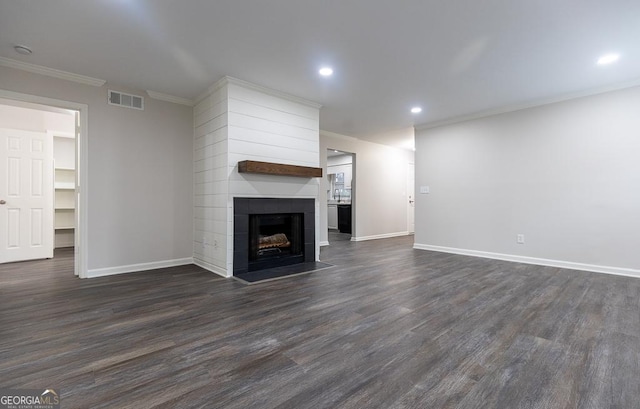 unfurnished living room featuring dark hardwood / wood-style flooring, crown molding, and a fireplace