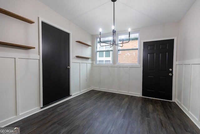 unfurnished dining area featuring dark wood-type flooring and a chandelier