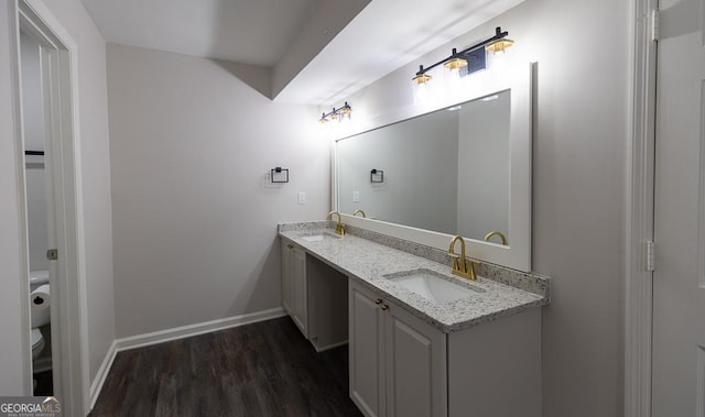 bathroom featuring wood-type flooring, vanity, and toilet