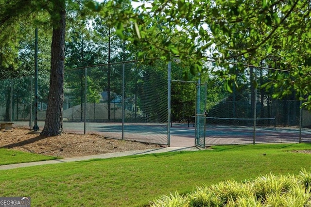 view of sport court with a yard