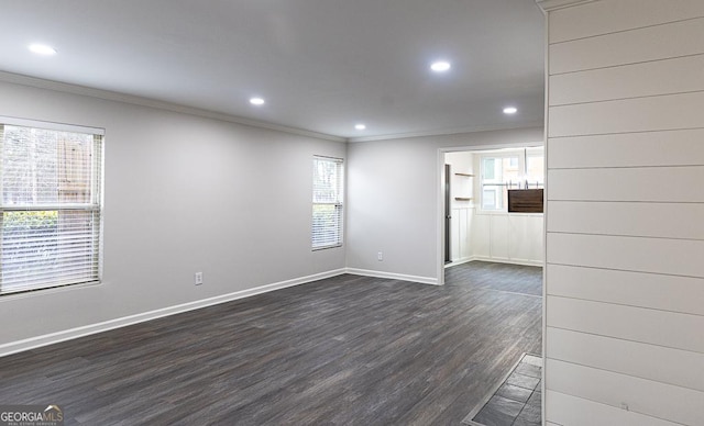 spare room featuring crown molding and dark wood-type flooring