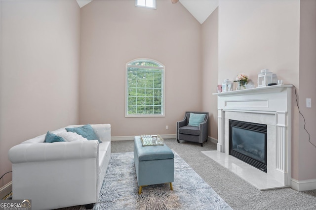 sitting room featuring carpet floors, a fireplace, high vaulted ceiling, and baseboards