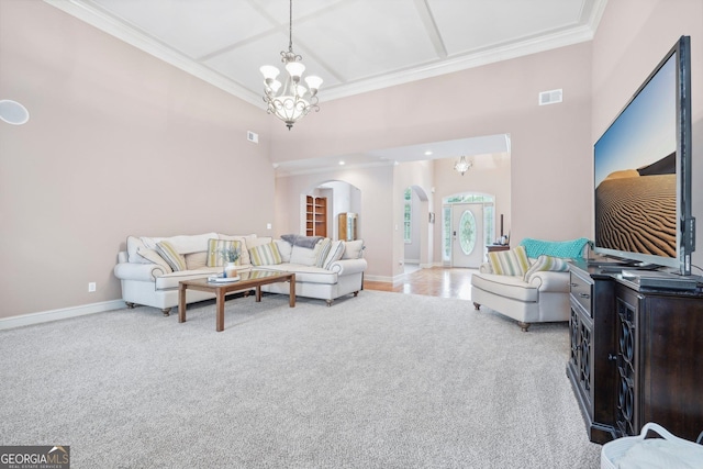 carpeted living room with arched walkways, a notable chandelier, visible vents, and crown molding