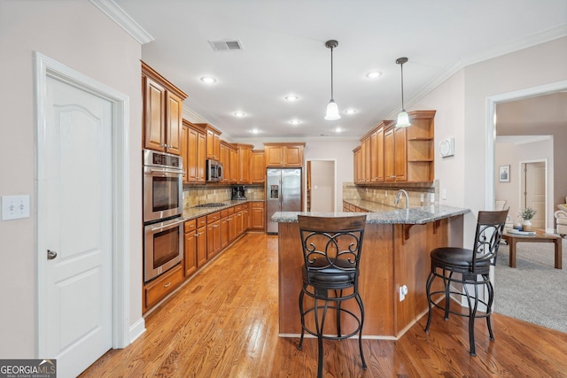 kitchen featuring light stone counters, open shelves, visible vents, appliances with stainless steel finishes, and a peninsula