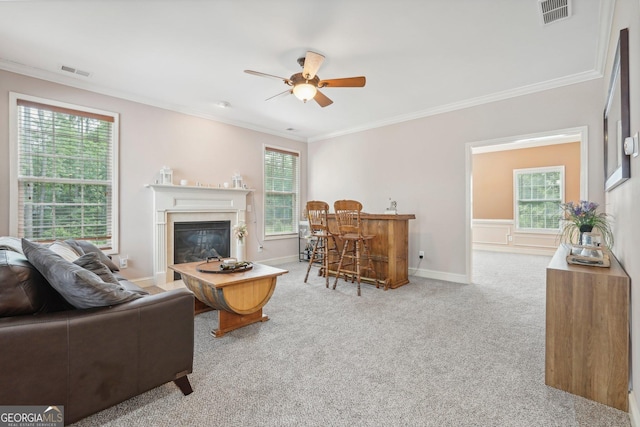 living area with carpet flooring, visible vents, and a healthy amount of sunlight