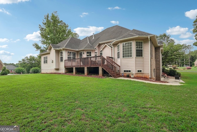 rear view of property featuring stairway, a deck, and a lawn