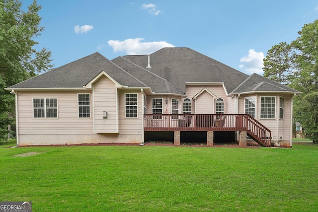 rear view of house featuring a shingled roof, stairs, a lawn, and a wooden deck