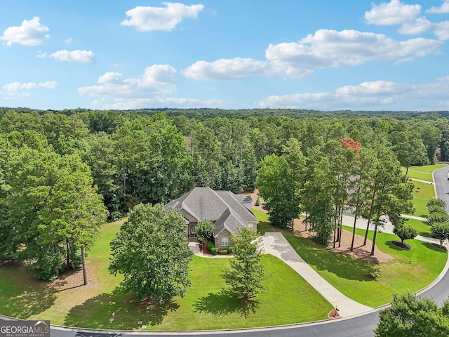 bird's eye view with a wooded view