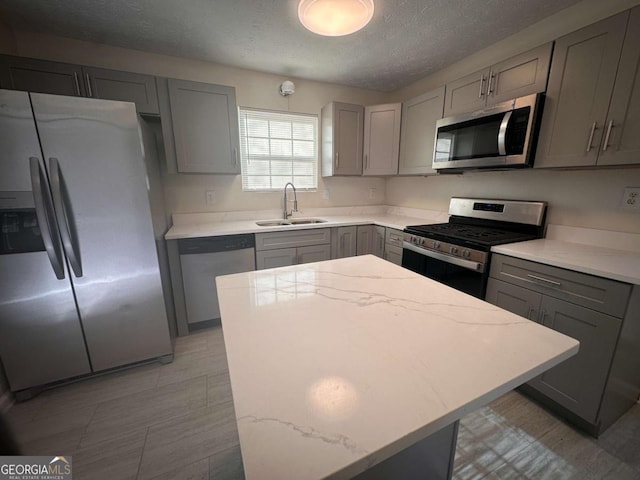 kitchen with gray cabinets, sink, and stainless steel appliances