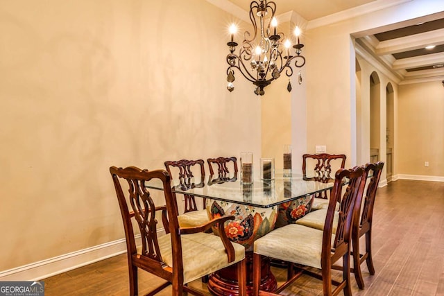 dining space with beamed ceiling, dark wood-type flooring, crown molding, and a chandelier