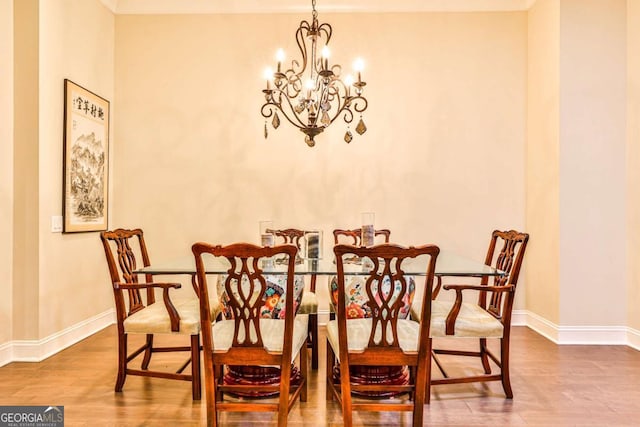 dining space featuring hardwood / wood-style floors and an inviting chandelier