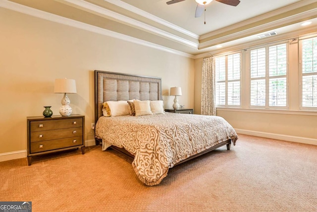 bedroom with ceiling fan, light colored carpet, crown molding, and a tray ceiling