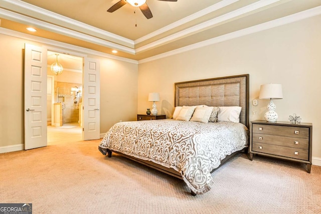 bedroom with carpet, a raised ceiling, crown molding, ensuite bath, and ceiling fan