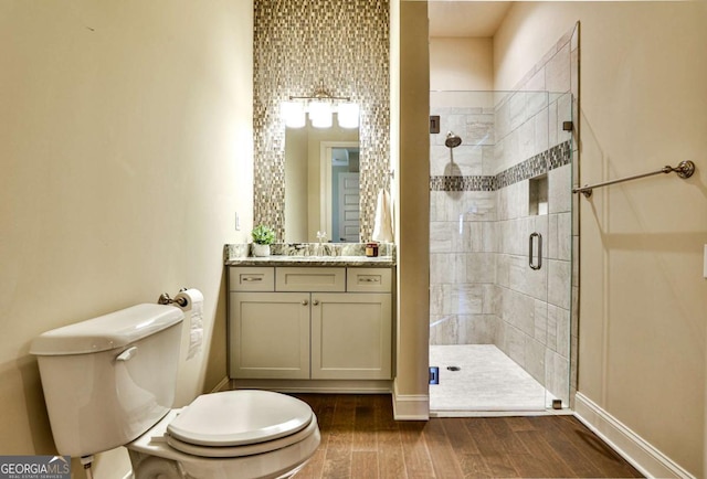 bathroom featuring vanity, toilet, and a shower with shower door