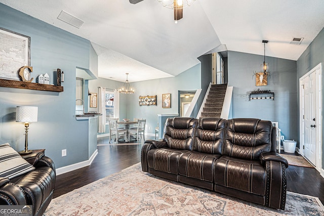 living room featuring dark hardwood / wood-style flooring, ceiling fan with notable chandelier, and vaulted ceiling