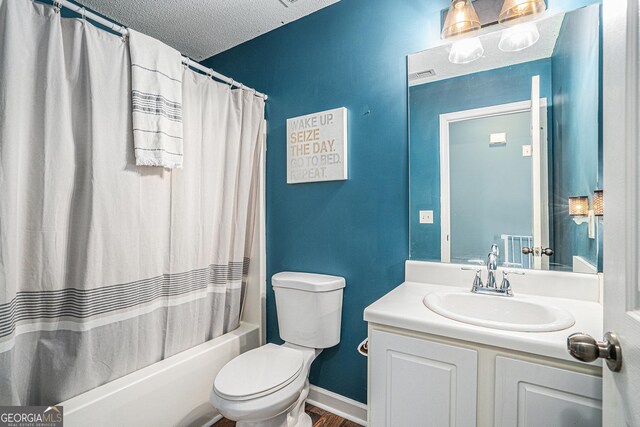 full bathroom featuring shower / bath combo, a textured ceiling, toilet, and vanity