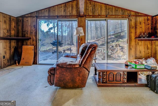 living area with carpet flooring, lofted ceiling, and wood walls