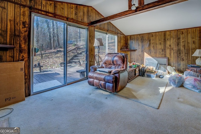 living room with vaulted ceiling with beams, carpet floors, and wooden walls