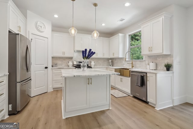 kitchen featuring white cabinetry, sink, stainless steel appliances, and light wood-type flooring