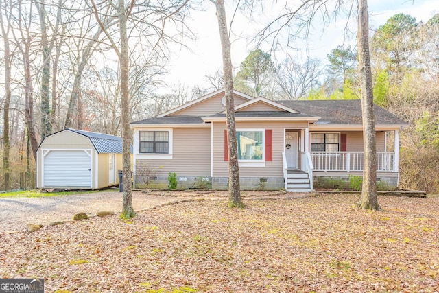 view of front of property with an outbuilding, a shingled roof, covered porch, a storage shed, and crawl space