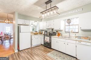 kitchen featuring white appliances, white cabinetry, light countertops, and pendant lighting