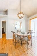 dining space featuring lofted ceiling, breakfast area, and wood finished floors