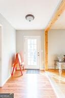 doorway featuring baseboards and wood finished floors