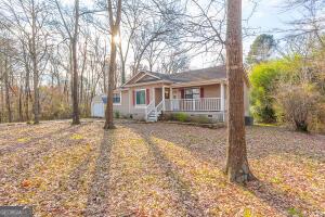 ranch-style home featuring a storage shed, a porch, crawl space, and an outdoor structure