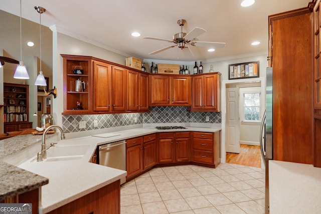 kitchen with decorative light fixtures, crown molding, sink, and appliances with stainless steel finishes