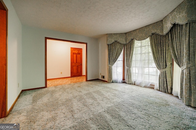 carpeted spare room featuring a textured ceiling