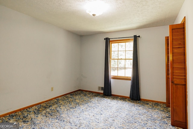 unfurnished room featuring a textured ceiling