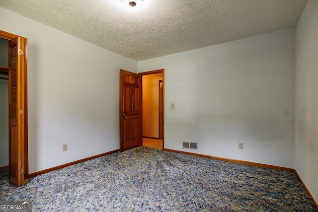 unfurnished bedroom featuring carpet and a textured ceiling