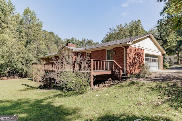 view of front of home with a garage, a front lawn, and a wooden deck