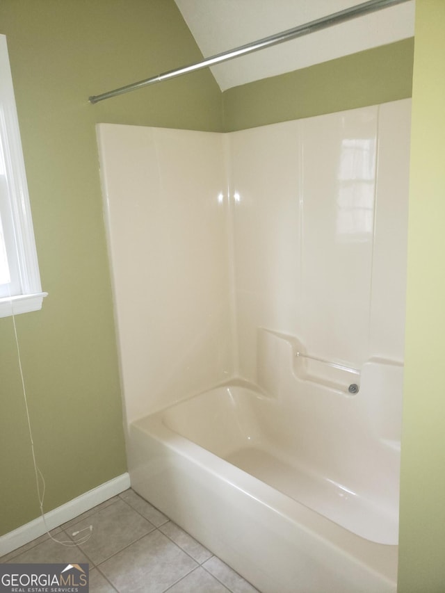 bathroom with tile patterned flooring and washtub / shower combination