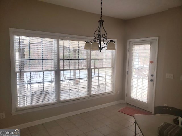 unfurnished dining area featuring tile patterned flooring and a chandelier