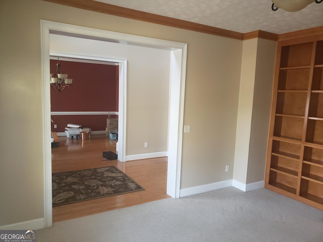 interior space with ornamental molding, light colored carpet, a textured ceiling, and an inviting chandelier